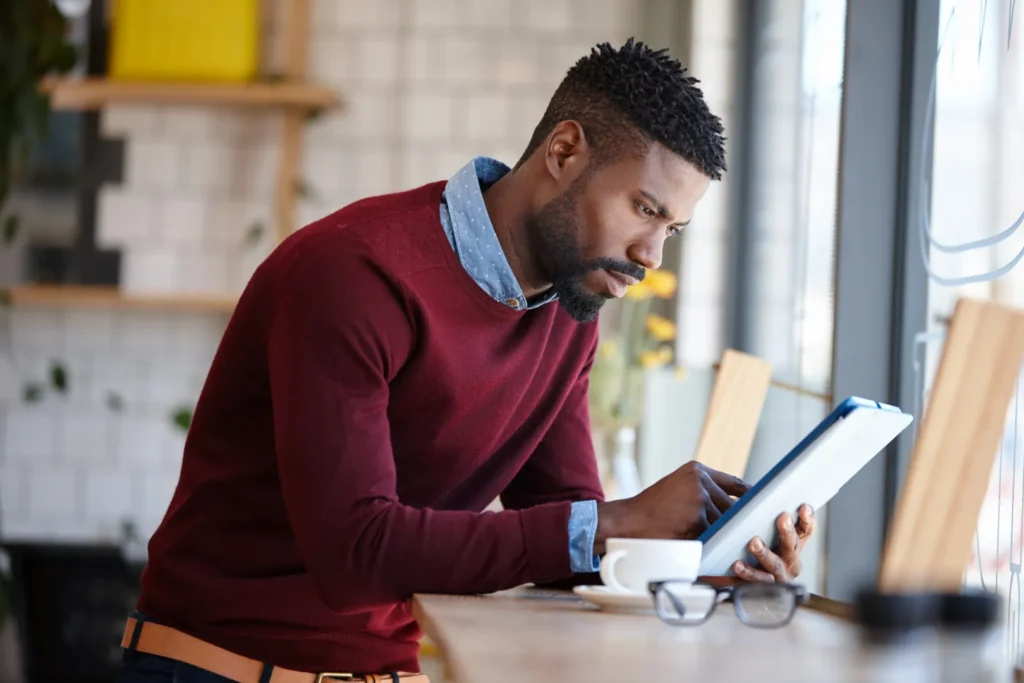 Man comparing private jet charter options on a tablet before booking a flight.